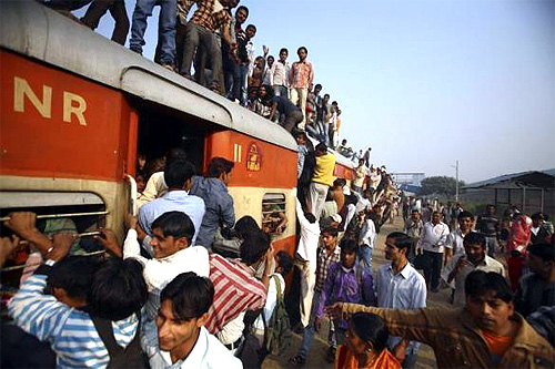 Commuters struggle to board a train at Noli railway station in Uttar Pradesh.