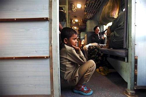 A child sits on the floor of a train heading towards Allahabad from Kanpur in Uttar Pradesh.