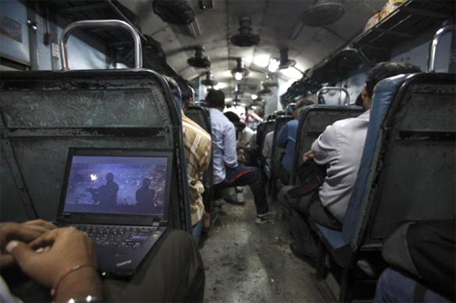 A man watches a film on his laptop as the train heads towards Agra from Delhi.