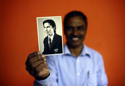 Train driver TS Unnikrishnan Nair, 60, who has been working for Indian Railways for 40 years, shows a picture taken when he first started his job, at his apartment in Mumbai.