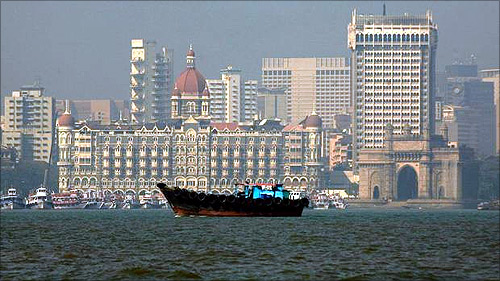 A fishing boat passes the Taj Mahal hotel in Mumbai.