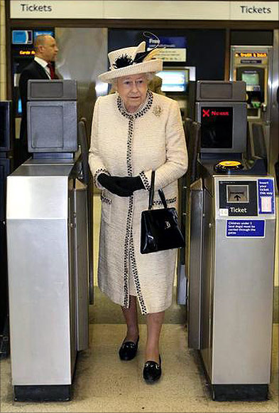 Britain's Queen Elizabeth walks through a ticket barrier during her visit to Baker Street underground station in London.