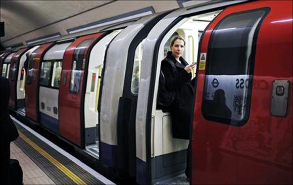 A woman waits for a tube train to depart at an underground station in London.