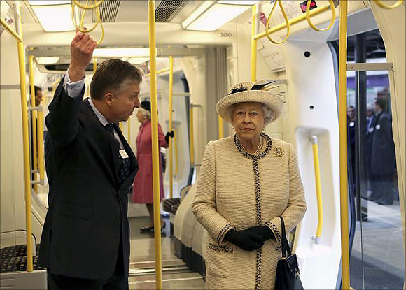 Britain's Queen Elizabeth speaks with a member of staff as she inspects a tube train during her visit to Baker Street underground station in London.