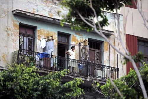 A woman stands with her child on the balcony of her apartment in Havana.