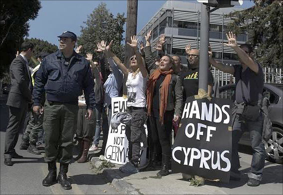Demonstrators raise their arms in protest as Cypriot President Nicos Anastasiades's convoy drives to the parliament in Nicosia.