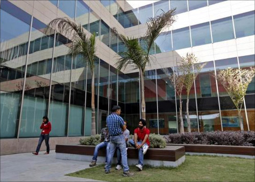 Employees chat during their lunch break inside Tech Mahindra office premises in Noida on the outskirts of New Delhi.