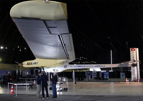 People stand below a wing on the Solar Impulse at Moffett Field in Mountain View, California.