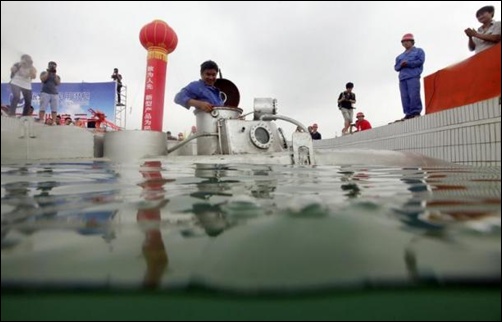 Zhang Wuyi sits in his double-seater submarine before taking it underwater during a test operation at an artificial pool near a shipyard in Wuhan, Hubei province.