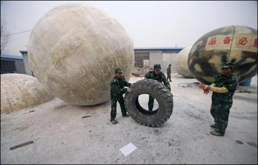 Workers move a tyre near spherical pods named Noah's Ark, designed by Chinese inventor Liu Qiyuan in Xianghe, Hebei province.