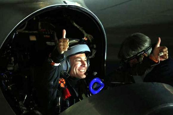 Solar Impulse pilot Bertrand Piccard gestures from the cockpit before taking off from Moffett Field to begin the first leg of his 2013 Across America Mission in Mountain View, California.