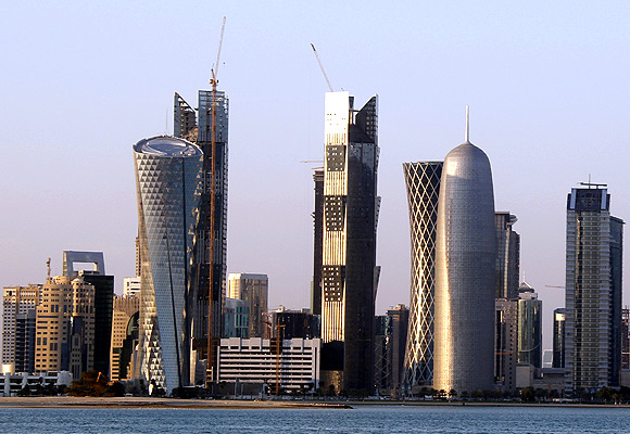 Sun reflects off the glass and steel buildings on the Doha skyline.
