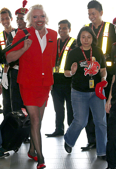 British entrepreneur Richard Branson, wearing an AirAsia stewardess uniform, speaks during an AirAsia promotional event after arriving at an airport in Sepang, outside Kuala Lumpur.