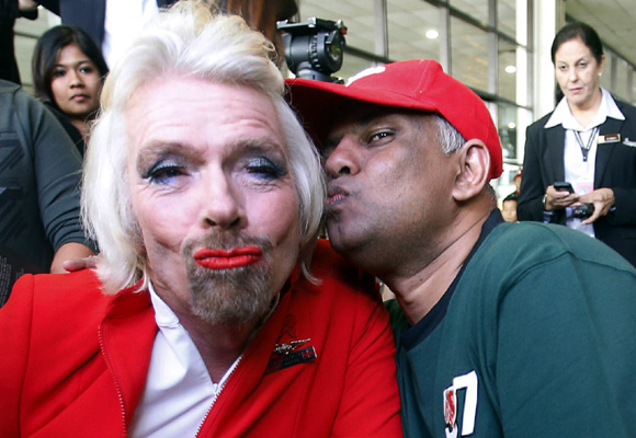 AirAsia's Chief Executive Tony Fernandes pretends to kiss British entrepreneur Richard Branson (L).