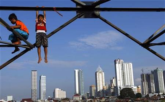Children play at an electricity pylon in Jakarta.