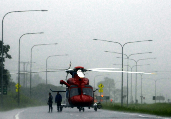 A helicopter blocks the road to traffic, due to flooding, on the highway to Toowoomba, 80 km (50 miles) southeast of Brisbane.