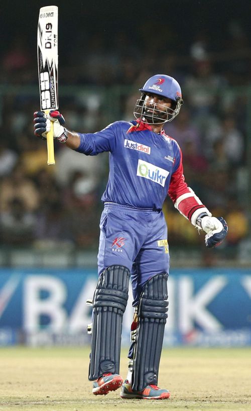 Dinesh Karthik raises his bat after his half-century