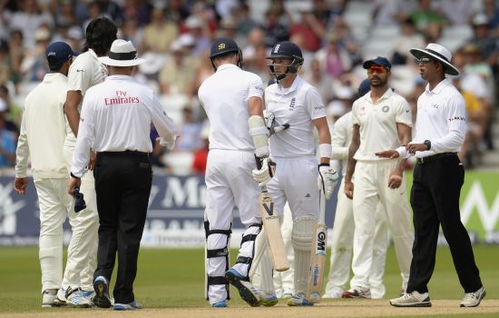 England's James Anderson (centre, L) pushes teammate Joe Root