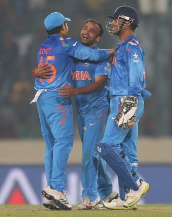 Amit Mishra is congratulated by Rohit Sharma and Mahendra Singh Dhoni