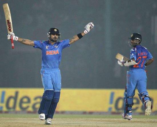 India's captain Virat Kohli celebrates after scoring a century as Ajinkya Rahane (R) watches during their Asia Cup 2014 match against Bangladesh
