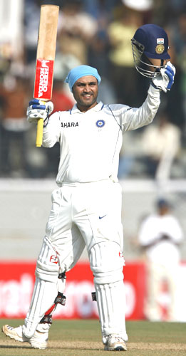 Virender Sehwag raises his bat on completing his double century