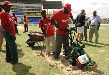 Groundsman dig up the bowler's run up at the Sir Vivian Richards stadium