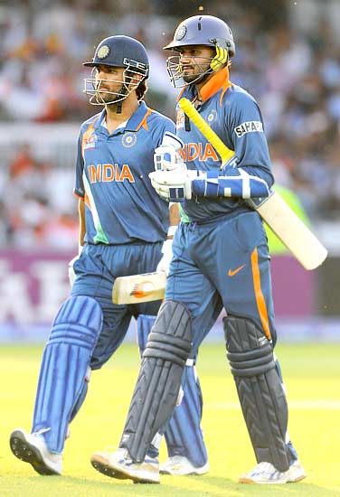 Mahendra Singh Dhoni (runner for Harbhajan) and Harbhajan Singh leave the field after being out caught