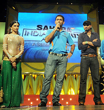 Dhoni (center) speaks as Harbhajan Singh (right) and Deepika look on
