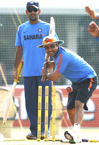 Virender Sehwag has a light batting session in the nets, as skipper MS Dhoni looks on