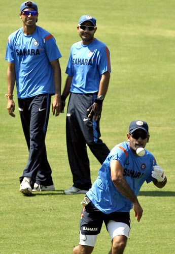 MS Dhoni throws the ball as Ashish Nehra and Virender Sehwag watch on, during practice on Tuesday