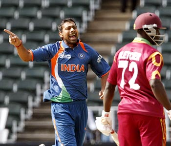Praveen Kumar celebrates after taking the wicket of Andre Fletcher