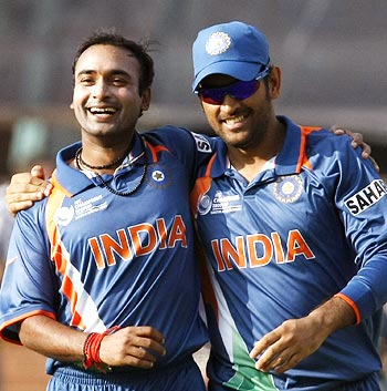 Amit Mishra (left) celebrates with Dhoni after taking the wicket of David Bernard