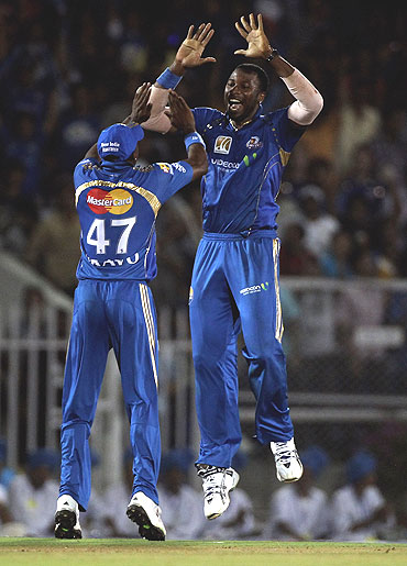 Kieron Pollard (right) and Dwayne Bravo celebrate the wicket of Rohit Sharma