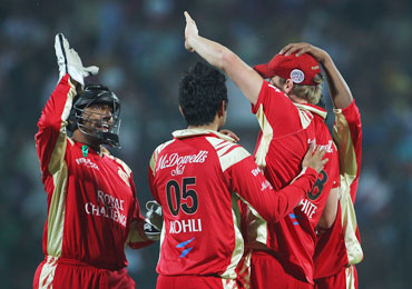 Royal Challengers players celebrate after a fall of a wicket