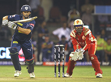 Adam Gilchrist hits a shot on the off-side as Robin Uthappa looks on