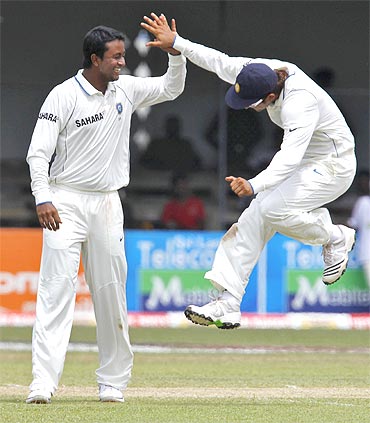 India's Pragyan Ojha (L) celebrates taking the wicket of Sri Lanka's Angelo Mathews with teammate Suresh Raina