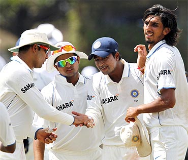 Teammates congratulate India's Pragyan Ojha (2nd R) after he took four Sri Lanka's wickets as they walk off the field