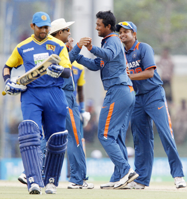 India's Pragyan Ojha (2nd R) celebrates taking the wicket of Sri Lanka's Tillakaratne Dilshan with teammates Virender Sehwag (2nd L) and Suresh Raina