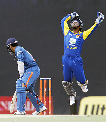 Sri Lanka's captain Kumar Sangakkara (right) celebrates after taking a catch to dismiss India's Dinesh Karthik