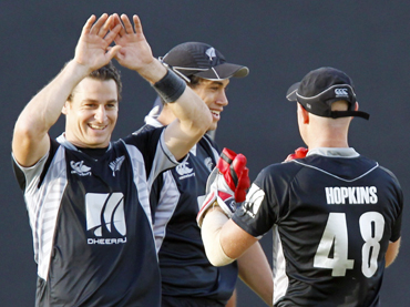 New Zealand's Nathan McCullum celebrates with teammate Gareth Hopkins (R) as captain Ross Taylor looks on