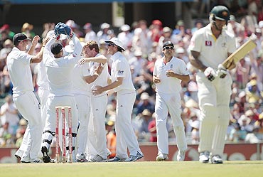 England players celebrate after taking the wicket of Australia's Mitchell Johnson (right)