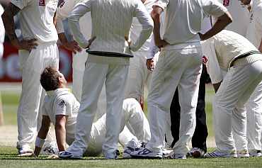 Australia's Ryan Harris is surrounded by team-mates during third day of the fourth Ashes Test in Melbourne