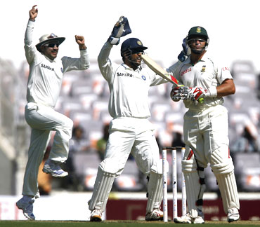India's Mahendra Singh Dhoni (centre) and Virender Sehwag celebrate the dismissal of South Africa's Jacques Kallis (right)