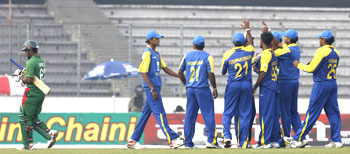 Bangladesh's Imrul Kayes leaves the field as Sri Lanka's fielders celebrate his dismissal