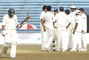 Bangladesh's Raqibul Hasan (left) walks back to the pavillion as Indian fielders celebrate his dismissal