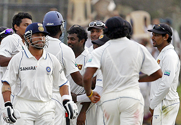 Muralitharan (centre) celebrates with teammates after dismissing Sachin Tendulkar (left)