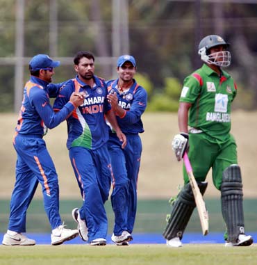 Praveen Kumar (centre) celebrates with team-mates after taking the wicket of Tamim Iqbal