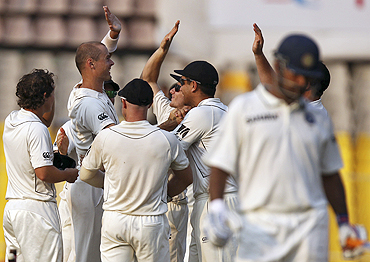 New Zealand's Chris Martin (2nd from left) is congratulated by teammates after claiming the wicket of Mahendra Singh Dhoni (right) on Sunday