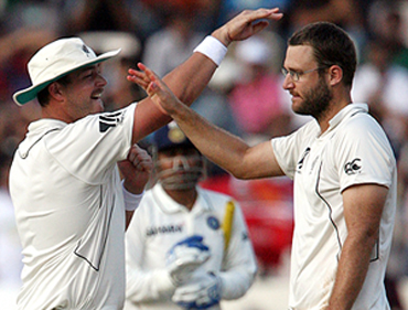 New Zealand's captain Daniel Vettori celebrates with Jesse Ryder after the dismissal of Sehwag on Saturday