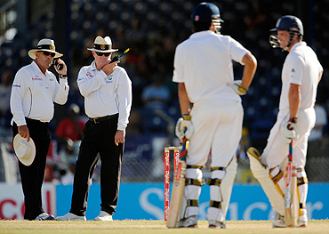 Umpires Daryl Harper (left) and Russell Tiffin wait for a referral verdict on England's Andrew Strauss (right), during a Test match in the West Indies earlier this year